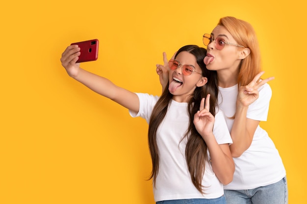 Glückliche Mutter und Kind machen Selfie auf dem Smartphone und zeigen Friedensblogger