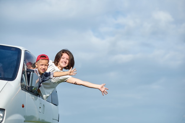 Glückliche Mutter und Sohn schauen aus den Fenstern und genießen Roadtrip. Familie reist mit dem Auto