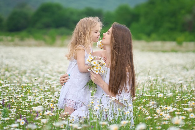 Glückliche Mutter und Tochter auf der Kamillenwiese