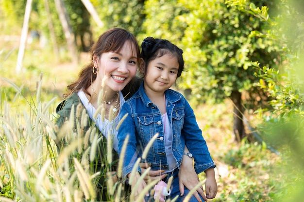 Glückliche Mutter und Tochter, die sich an einem schönen Morgen im Park amüsieren. Glückliches asiatisches Familienkonzept family