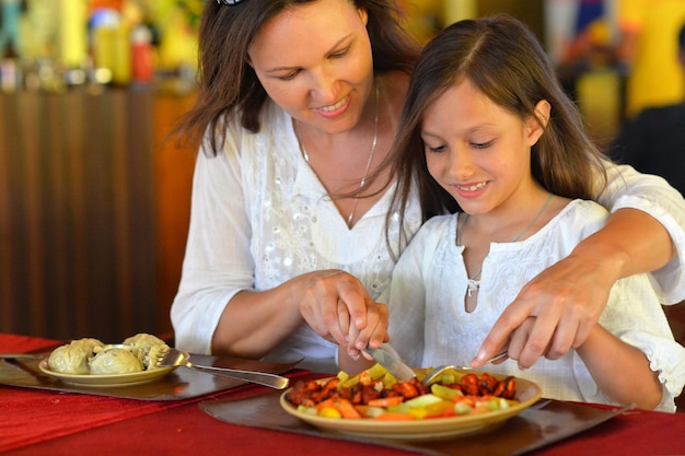 glückliche mutter und tochter, die zusammen im café essen