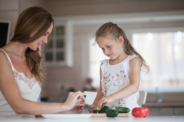 Glückliche Mutter und Tochter, die zusammen kochen