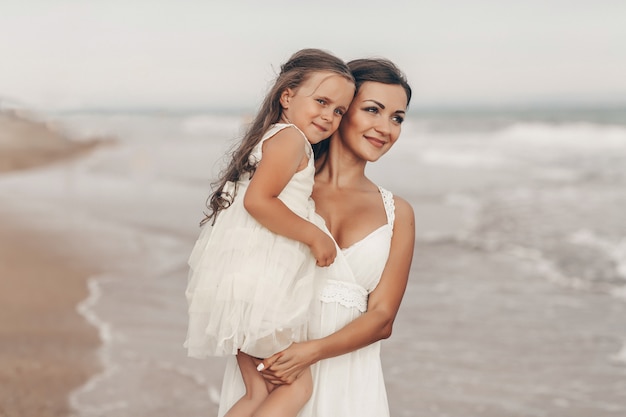 Glückliche Mutter und Tochter genießen sonnigen Tag am Strand