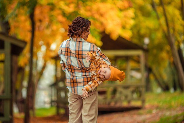 Glückliche Mutter und Tochter haben Spaß bei einem Herbstspaziergang im Park in der Natur