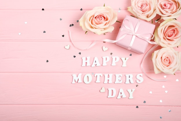 Glückliche Muttertagsdekorationen, Blumenstrauß und Geschenke auf rosa Hintergrund