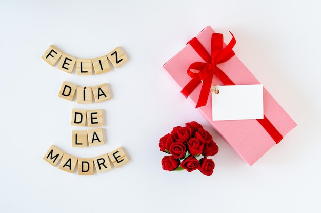 Glückliche Muttertagsgrußkarte mit Geschenkbox und Rosen auf weißem Hintergrund