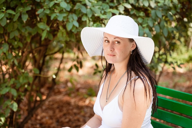 Glückliche nette Brunettefrau im Park am Sommertag Fröhliche schöne Frau