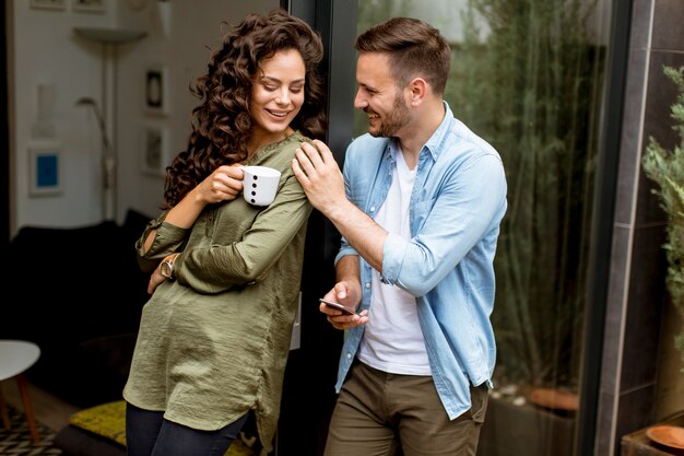 Glückliche nette Paare in der Liebe, die sich umfasst und Kaffee trinkt