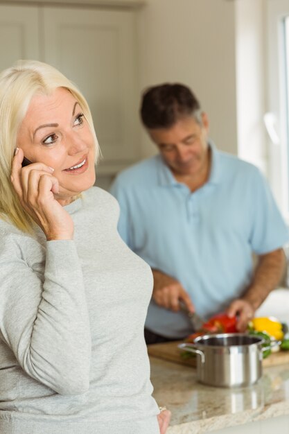 Glückliche reife Blondine am Telefon