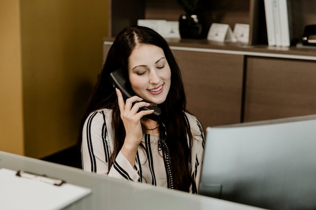 Glückliche Rezeptionistin am Telefon