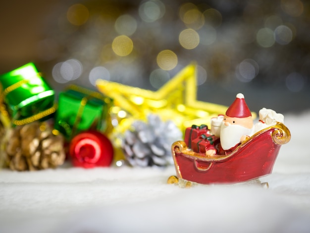 Glückliche Santa Claus mit Geschenkbox auf dem Schneeschlitten ist Weihnachtsdekor.