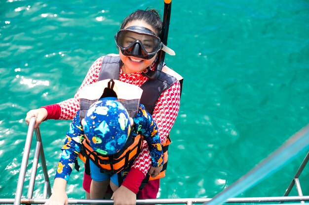 Glückliche Schnorchelmutter und -sohn haben Spaß beim Schnorcheln im Meerwasser im Karibikurlaub in Thailand?