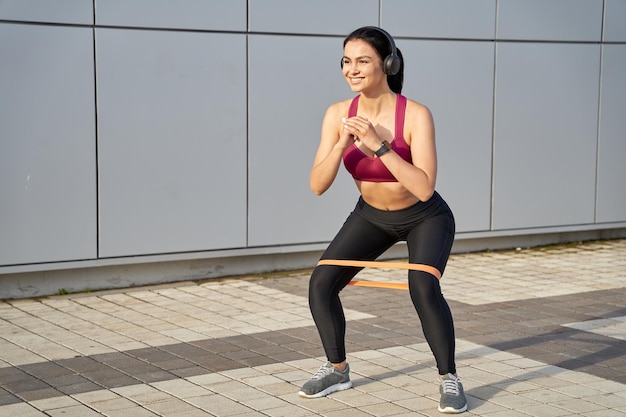 Glückliche schöne Frau, die beim Hocken Musik hört