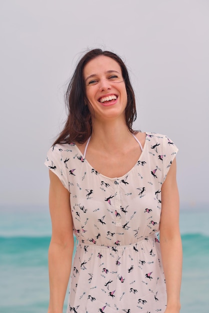 Glückliche schöne Frau, die Sommerferien am Strand genießt