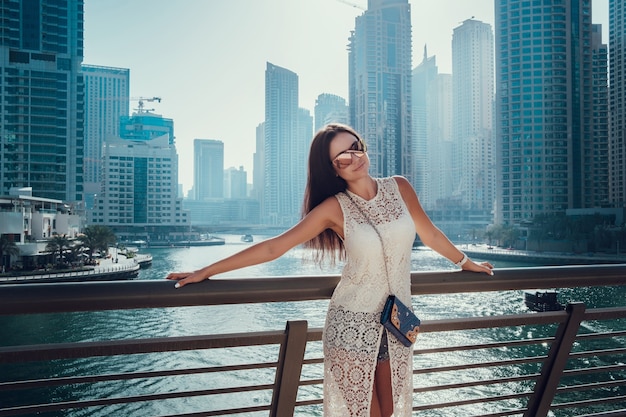 Glückliche schöne unerkennbare Touristenfrau im modischen weißen Sommerkleid, das in Dubai genießt