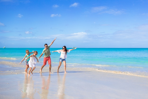 Glückliche schöne vierköpfige Familie am Strand