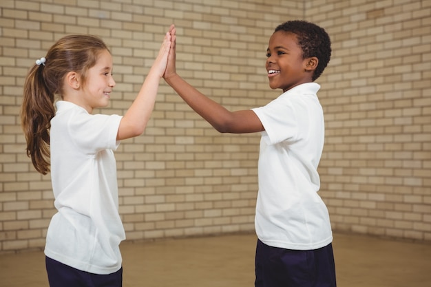 Glückliche Schüler, die sich Hoch fünf geben