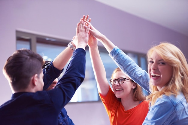 Foto glückliche schüler feiern freunde versammeln sich in der schule junge leute heben die hände, stapeln sich und bilden gemeinsam einen kreis