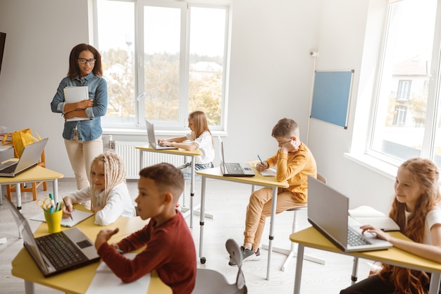 Glückliche Schüler schreiben während einer Unterrichtsstunde in der Schule