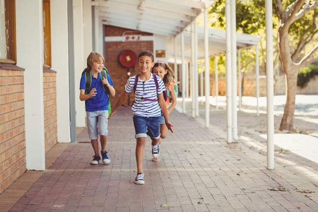 Glückliche Schulkinder, die in Korridor laufen