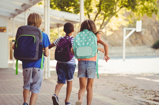 Glückliche Schulkinder, die in Korridor laufen