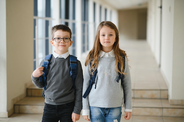 Glückliche Schulkinder im Korridor in der Schule Lernkonzept