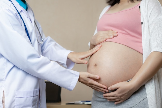 Glückliche schwangere Frau besuchen Gynäkologen Arzt im Krankenhaus oder in der Klinik für Schwangerschaftsberater.