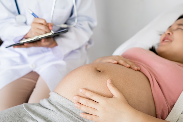 Glückliche schwangere Frau besuchen Gynäkologen Arzt im Krankenhaus oder in der Klinik für Schwangerschaftsberater.