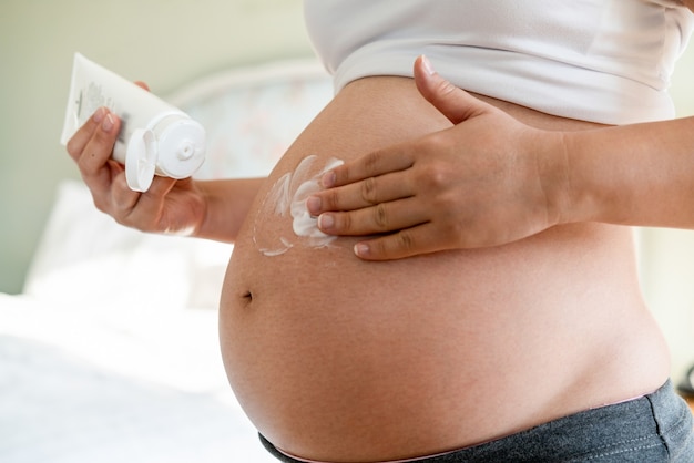 Glückliche schwangere Frau mit Baby im schwangeren Bauch. Schwangerschaftsvorsorge und Schwangerschaft der Frau.