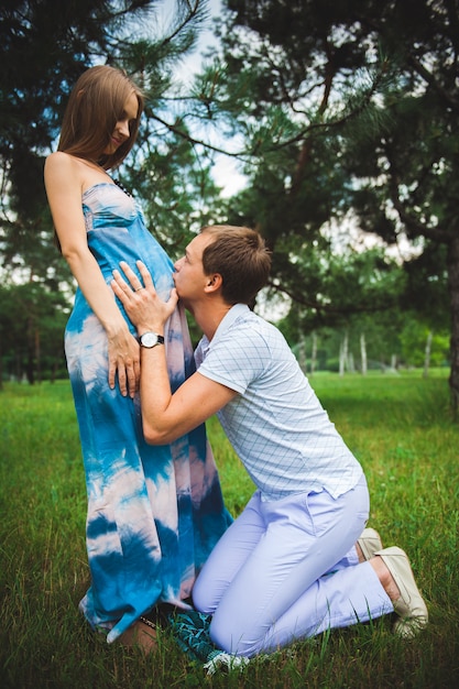Glückliche schwangere Paare im Sommerpark