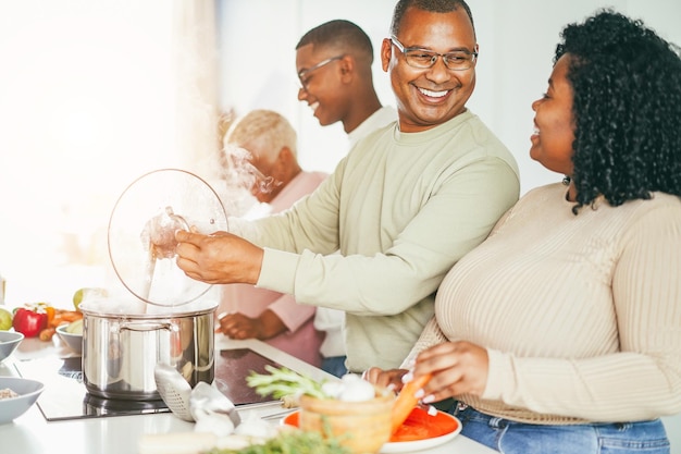 Glückliche schwarze Familie, die zu Hause in der Küche kocht. Konzentrieren Sie sich auf das Gesicht des Vaters