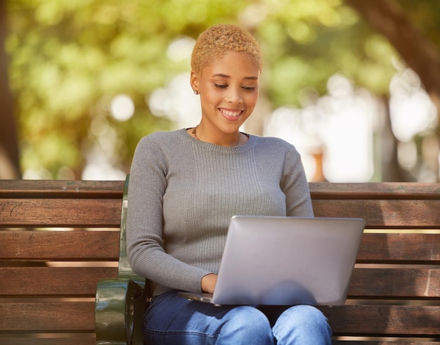 Glückliche schwarze Frau, Laptop und Outdoor, entspannen sich bei Sonnenschein auf einer Bank in der Stadt, Online-Jobsuche oder Remote-Arbeit im Park