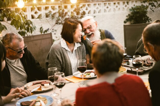 Glückliche Senioren, die Spaß beim Grillabendessen haben