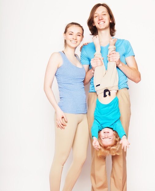 Glückliche sportliche Familie - Mutter, Vater und kleiner Sohn posieren auf weißem Hintergrund