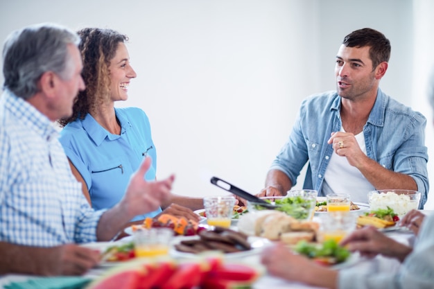 Glückliche sprechende Familie beim Frühstücken