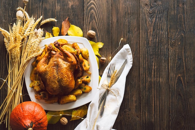 Glückliche Thanksgiving-Herbstkomposition mit reifen Blättern, Kürbis und Thanksgiving-Türkei auf einem dunklen Holztisch