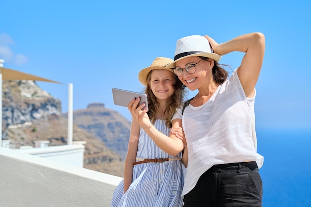 Glückliche Touristen, Mutter und Tochter, die ein Selfie-Foto auf dem Smartphone machen, während sie auf der Insel Santorin unterwegs sind. Familienausflug, berühmte Reiseziele