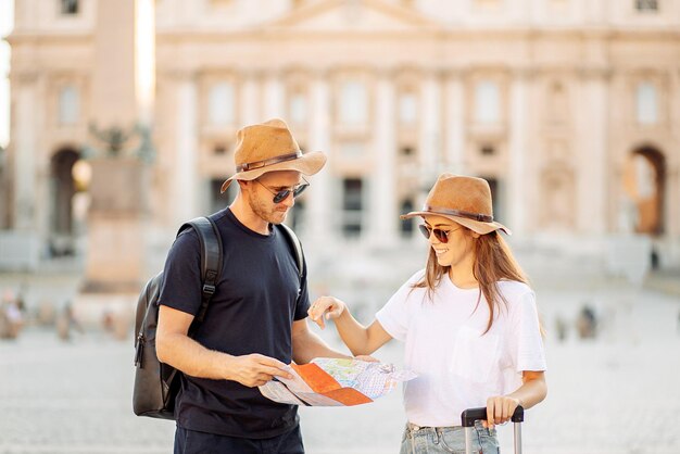 Foto glückliche touristen schauen sich eine karte an und wählen ein hotel ein paar touristen im urlaub in rom, italien