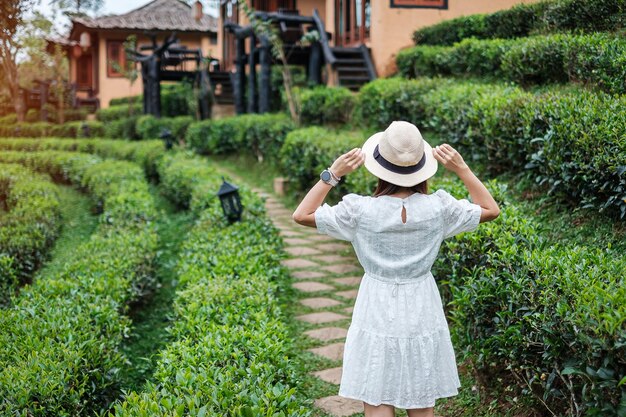 Glückliche Touristenfrau im weißen Kleid genießen schönen Teegarten.