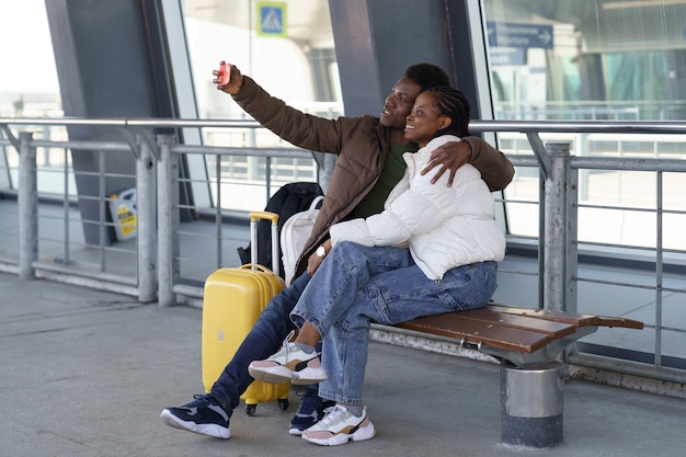 Glückliche Touristenpaare machen Selfie am Flughafen