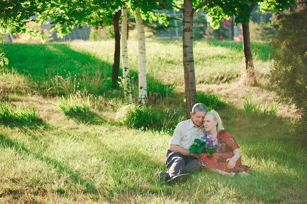 Glückliche und alte Leute, die im Park sitzen