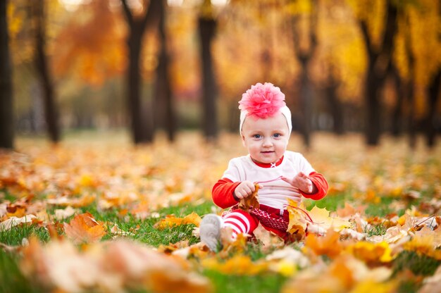 Glückliche und kleine Frau spielt im Herbstpark