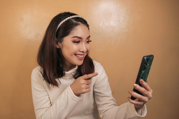 Glückliche und lächelnde junge asiatische Frauen im Telefon