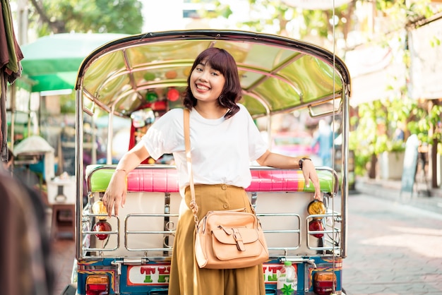 Glückliche und schöne asiatische Frau, die an Khao Sarn Road, Thailand reist