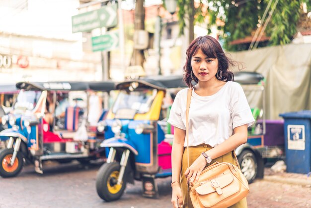 Glückliche und schöne asiatische Frau, die an Khao Sarn Road, Thailand reist