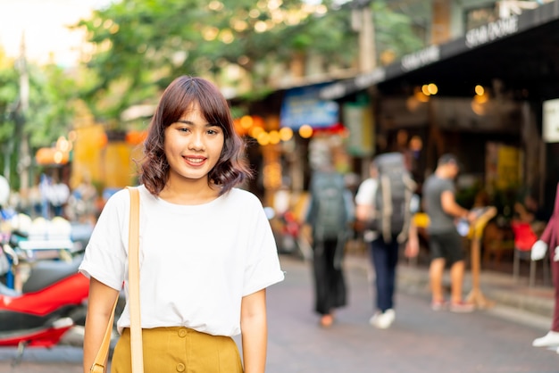 Glückliche und schöne asiatische frau, die an khao sarn road, thailand reist