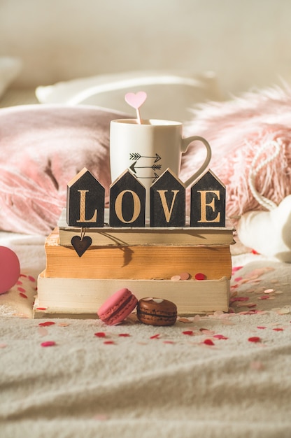 Glückliche Valentinstagpostkarte. Liebeskonzept für Muttertag und Valentinstag. Herzen und die Bücher mit Tasse Kaffee. Valentinskarte mit Platz für Text