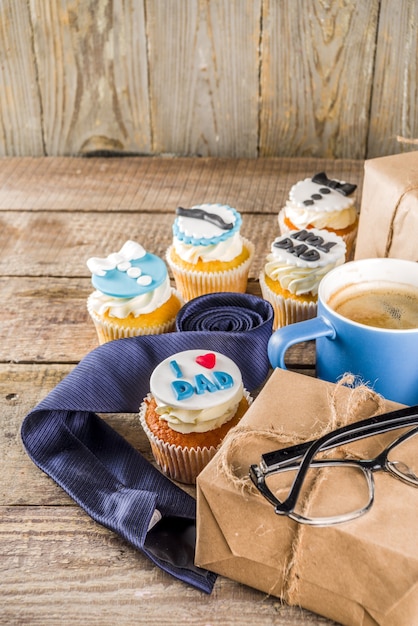 Glückliche Vatertagsgrußkarte. Grüße und Geschenke zum Vatertag - Geschenkbox, Kaffee-Tee-Tasse, Krawatte, hausgemachte Spezial-Cupcakes.