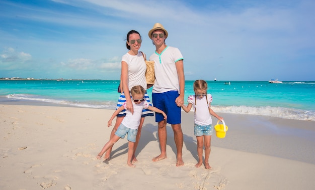 Glückliche vierköpfige Familie auf tropischen Ferien des Strandes