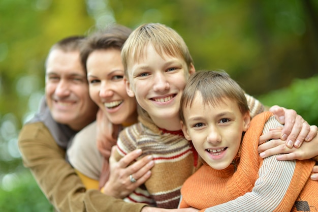 Foto glückliche vierköpfige familie, die im herbst zusammen im park steht